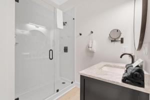 a white bathroom with a shower and a sink at 27 on Park Boutique Hotel & Venue in Dahlonega