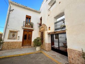 Edificio blanco con puerta y balcón en Apartamentos Ca Federo, Casa la Tía Elena 