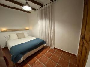 1 dormitorio con 1 cama con manta azul en Apartamentos Ca Federo, Casa la Tía Elena, 