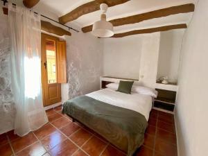 a bedroom with a bed and a ceiling at Apartamentos Ca Federo, Casa la Tía Elena in Losa del Obispo