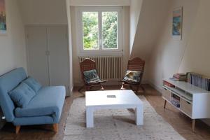 uma sala de estar com um sofá azul e uma mesa de centro em Maison familiale proche plages, centre-ville em Concarneau