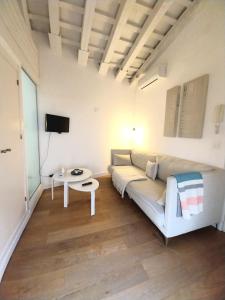ein Wohnzimmer mit Sofa und Tisch in der Unterkunft Estudio Boutique Arenal - Cama buhardilla in Jerez de la Frontera