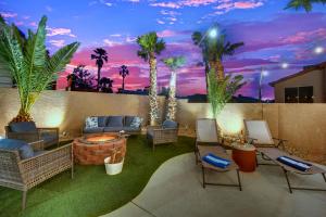 a patio with chairs and a fire pit with palm trees at Heritage Haven Villa in Las Vegas