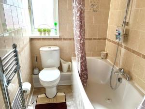 y baño con aseo, bañera y ducha. en 3 BDR House ,Free Parking ,Netflix ,WiFi, Near City Centre and Stockport en Mánchester