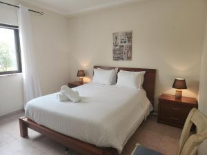 a bedroom with a large white bed with two lamps at Sunny House in Lagos