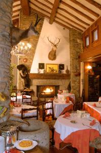 a restaurant with tables and a fireplace in a room at Le Jardin in Saillagouse