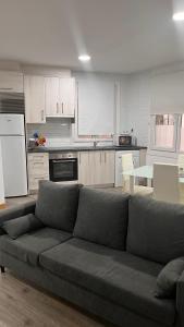 a living room with a couch and a kitchen at La de Fredyy - Tres Marias Apartments in Redondela