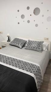 een slaapkamer met een groot bed met grijze kussens bij La de Fredyy - Tres Marias Apartments in Redondela