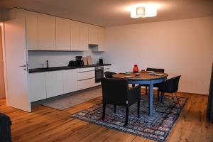 een kamer met een tafel en stoelen en een keuken bij Ferienwohnung Bodenseeblick Nr 7 in Scheidegg