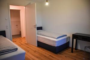een kleine slaapkamer met 2 bedden en een bureau bij Ferienwohnung Bodenseeblick Nr 7 in Scheidegg