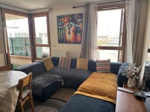 a living room with a blue couch and windows at Charmant appartement sacré cœur avec parking gratuit in Paris