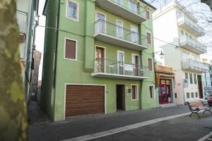 a green building with a garage on a street at CasaDilva in Chioggia