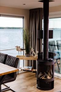 a fireplace in a living room with a view of the water at Hausboot Dory in Ribnitz-Damgarten