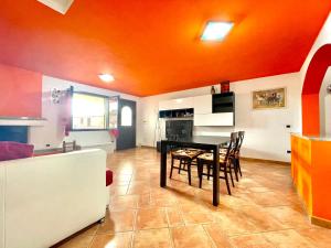 Una cocina y un comedor con mesa y sillas. en Orange House, en Bari Sardo 15 fotos más