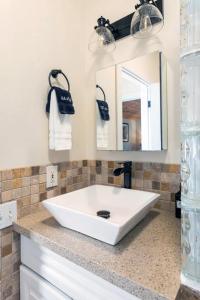 a white sink in a bathroom with a mirror at Hale Ho'okipa in Volcano +59 photos