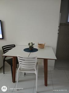 a white table and a white chair with a plant on it at Apartamento copacabana Beach in Rio de Janeiro