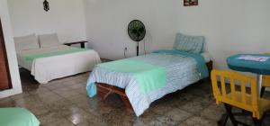 1 dormitorio con 2 camas y mesa en rooms megi terminal, en Cahuita