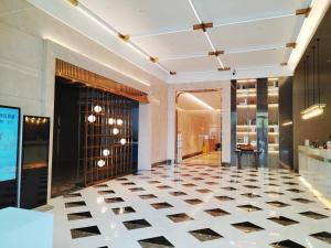 a lobby with a black and white checkered floor at HT Legend Hotel Changgang Metro Station Exit F - Free Shuttle Bus to Canton Fair Complex During Canton Fair Period in Guangzhou
