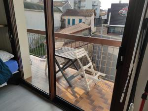 a table and chair on a balcony with a view at Studio proche centre-ville et gare in Dax