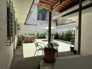 een patio met een tafel en stoelen en een parasol bij Casa Recife Pousada in Recife