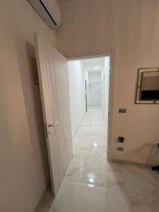 un corridoio con pareti bianche e una porta bianca di Lupo Luxury Rooms a Bologna