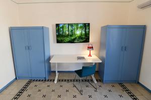 um quarto com armários azuis e uma secretária com um candeeiro em La Ciriciccia em Acireale