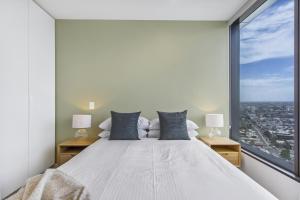 a bedroom with a large bed with a large window at Atop the Melbourne CBD with Panoramic Views in Melbourne