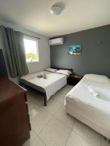 Habitación de hotel con 2 camas y ventana en Residencial Fran Chiattone, en Natal