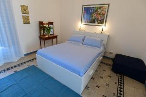 um quarto com uma cama grande e lençóis azuis em La Ciriciccia em Acireale