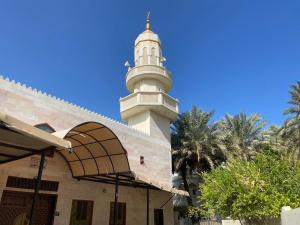 una mezquita con una torre en la parte superior de un edificio en MOHAMMAD HOSTEL en Mascate