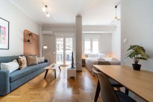 uma sala de estar com um sofá, uma cama e uma mesa em Aris123 by Smart Cozy Suites - Apartments in the heart of Athens - 5 minutes from metro - Available 24hr em Atenas