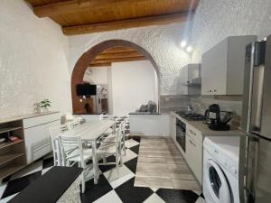 a kitchen with a table and chairs in a room at Il Cortiletto di Ortigia in Syracuse