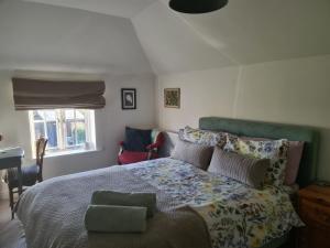 a bedroom with a large bed with a green headboard at Brisley North Norfolk cosy cottage garden pub and walks in Beetley