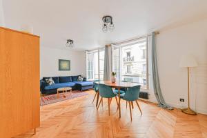 uma sala de estar com uma mesa e um sofá azul em PANTHEON em Paris