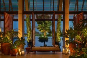 a lobby with a swing and a pool of water at The Riviera Maya EDITION at Kanai in Playa del Carmen