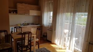 uma cozinha com uma mesa e uma cozinha com uma janela em Apartmani Kesten-Vrnjačka Banja em Vrnjačka Banja