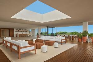 a living room with white furniture and a large skylight at The Riviera Maya EDITION at Kanai in Playa del Carmen