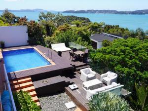 a backyard with a pool and a table and chairs at Luxury Palms in Paihia