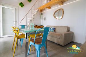 a dining room with a blue table and yellow chairs at Acquamarina B&Beach in Follonica