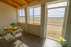 a room with a table and chairs and a window at Acquamarina B&Beach in Follonica