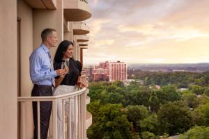 un hombre y una mujer de pie en el balcón de un edificio en The Ritz-Carlton, St. Louis, en Clayton