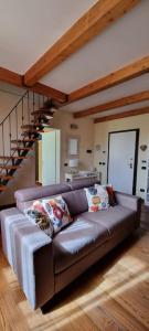 un divano in un soggiorno con scala di Appartamento La casina di Chiara a Livorno