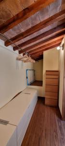 リヴォルノにあるAppartamento La casina di Chiaraの白いベッドが備わるウッドフロアの客室です。