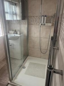 a shower with a glass door next to a sink at Modern 4 Bed House for 9 guests in Tilbury