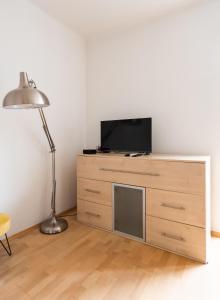 a room with a tv on a dresser with a lamp at Metro Ratusz Arsenał Comfort Studio in Warsaw