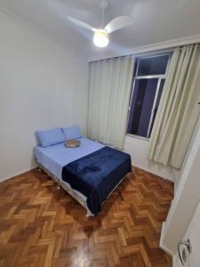 een slaapkamer met een bed en een plafondventilator bij Copacabana_simples_Wifi_praia_ar in Rio de Janeiro