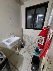 a bathroom with a sink and a window at Apartamento mobiliado e confortável em candeias in Recife