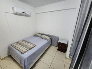 Apartamento mobiliado e confortável em candeias في ريسيفي: غرفة نوم صغيرة بها سرير وسخان