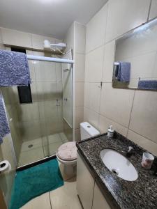 y baño con aseo, lavabo y ducha. en Apartamento mobiliado e confortável em candeias, en Recife