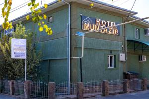 a hotel with a sign on the side of a building at Muntazir Hostel in Yakkasaray